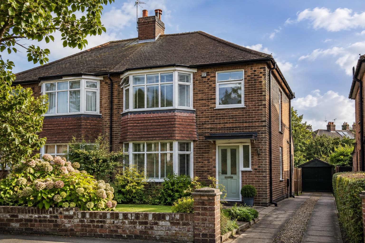 Exterior view of a weathered British semi-detached house showing brickwork and guttering typical of an older property