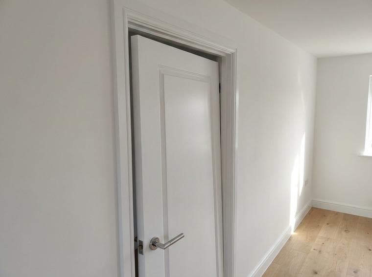 The bedroom door remained out of line with the frame and did not latch when the handle was released during the operation check.